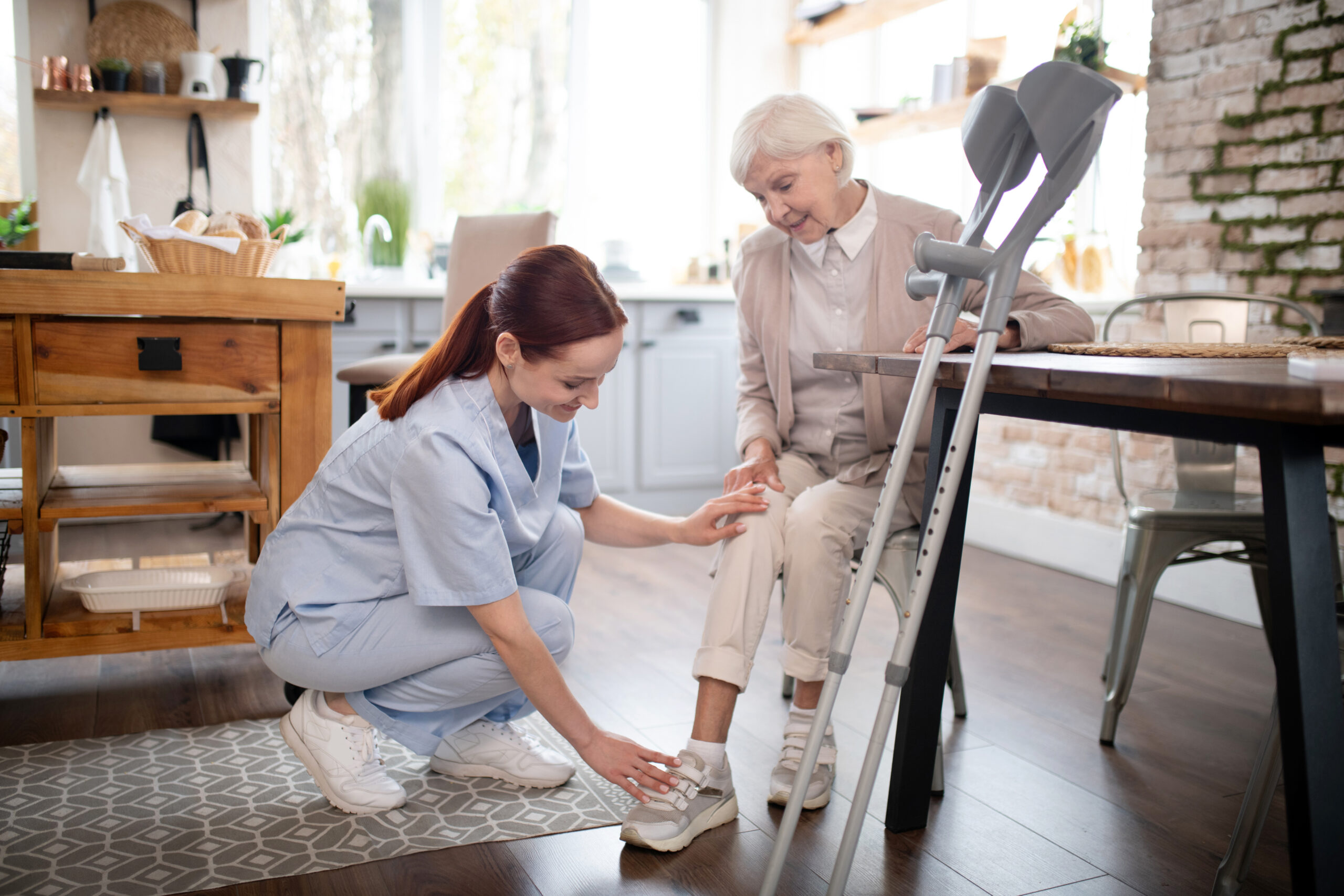 Nurse taking care. Helpful diligent nurse wearing uniform taking care of aged woman